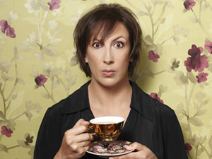 Miranda Hart with cup and saucer and floral background